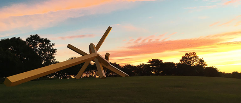 A large yellow steel sculpture titled ‘Illinois Landscape No. 5’ at sunset